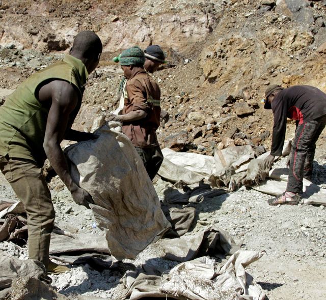 Artisanal miners handle ore at an open-pit copper-cobalt site in the DRC