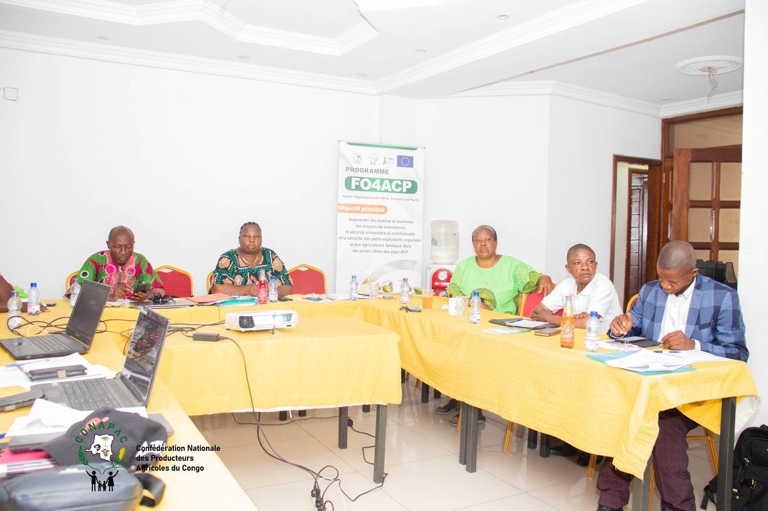 Farmer-organisation delegates meet beside a CONAPAC programme banner