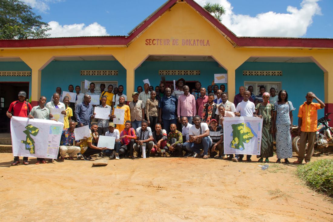 Community members hold hand-drawn maps of their local forest concessions during a GASHE participatory mapping session