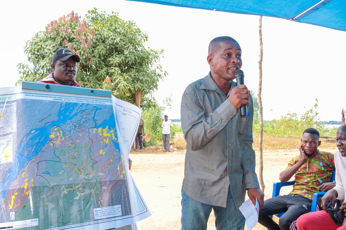 A GASHE participant presents a deforestation and peatland monitoring map to community members